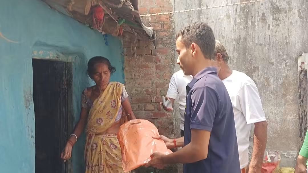 Elderly woman receiving clothes from a volunteer