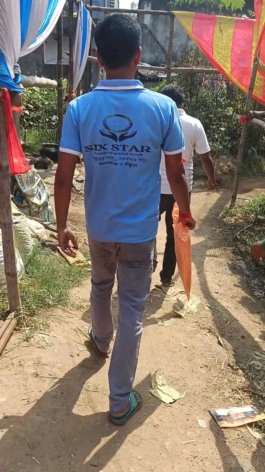 Six Star volunteer walking through the village