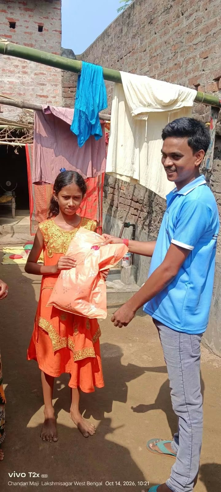 Girl receiving new clothes in Laxmisagar