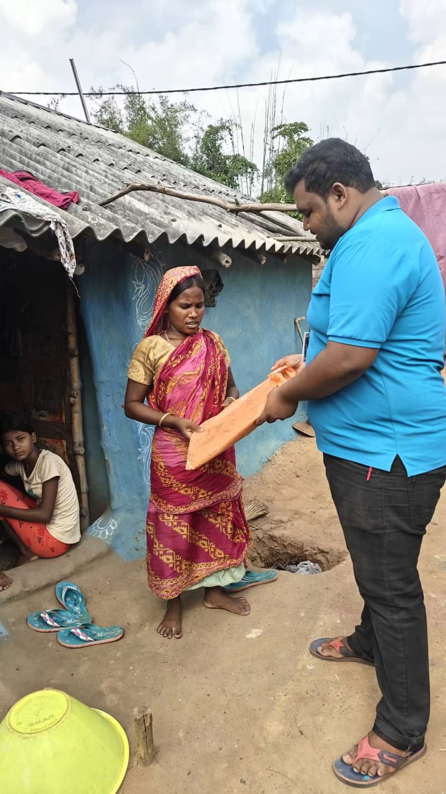 Volunteer handing clothes to an elderly woman